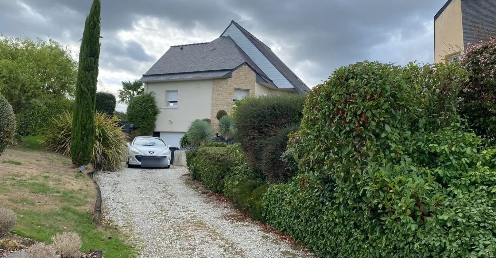 Avant : allée de gravillons et haie devant la maison, à Ploeren